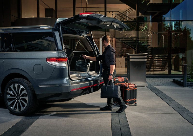 A valet is unloading luggage from the rear cargo area of a 2023 Lincoln Navigator SUV. | Haldeman Lincoln in Allentown PA