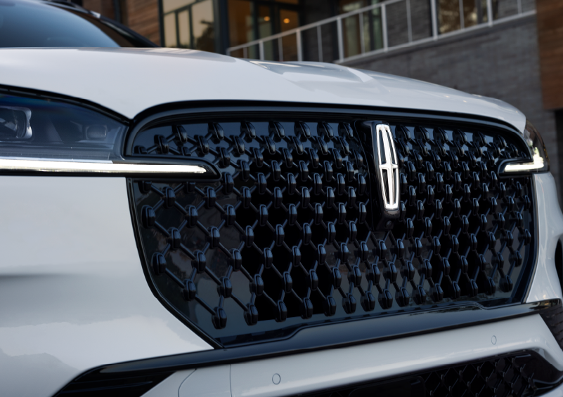 The black grille of a white 2025 Lincoln Aviator® SUV is shown with its fog lights on. | Haldeman Lincoln in Allentown PA