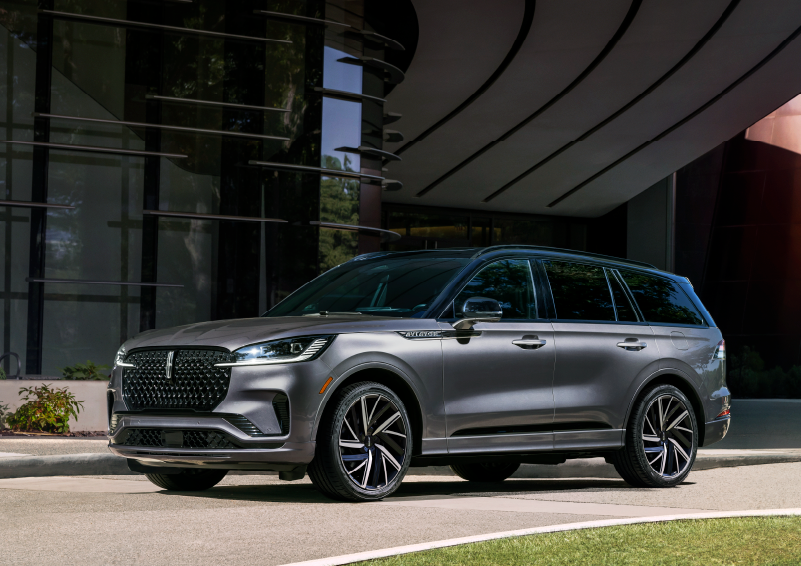 A gray 2025 Lincoln Aviator® SUV is parked outside a modern building showcasing the driver’s side of the vehicle. | Haldeman Lincoln in Allentown PA