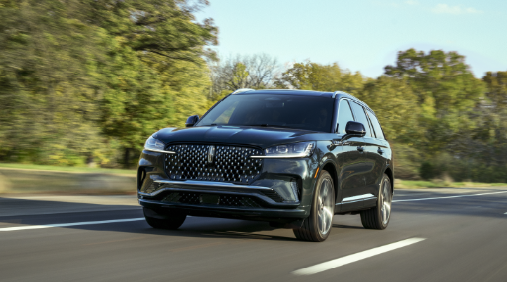 A 2025 Lincoln Black Label Aviator® SUV is being driven down a road lined with trees. | Haldeman Lincoln in Allentown PA