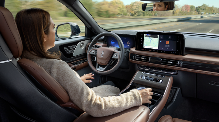 A woman is seen sitting in the driver’s seat of her 2025 Lincoln Aviator® SUV with her hands off the steering wheel. | Haldeman Lincoln in Allentown PA
