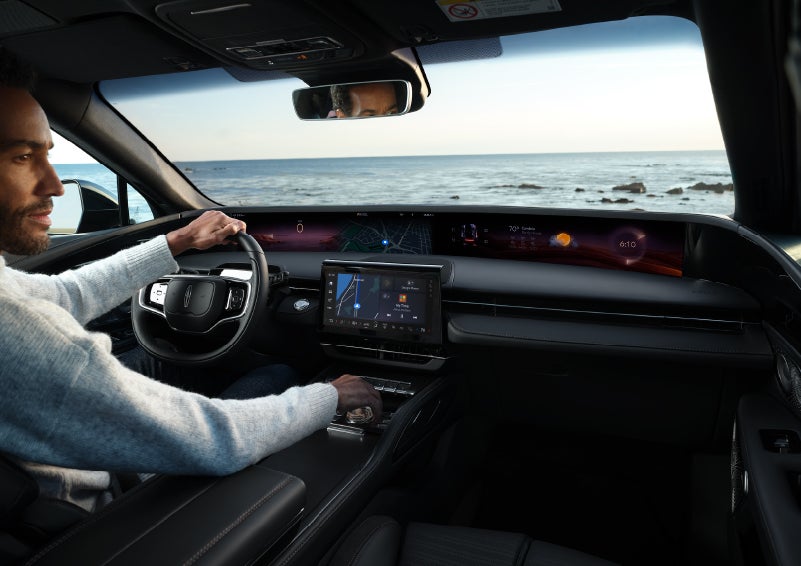 A driver of a parked 2025 Lincoln Nautilus® SUV takes a relaxing moment at a seaside overlook while inside his Nautilus. | Haldeman Lincoln in Allentown PA