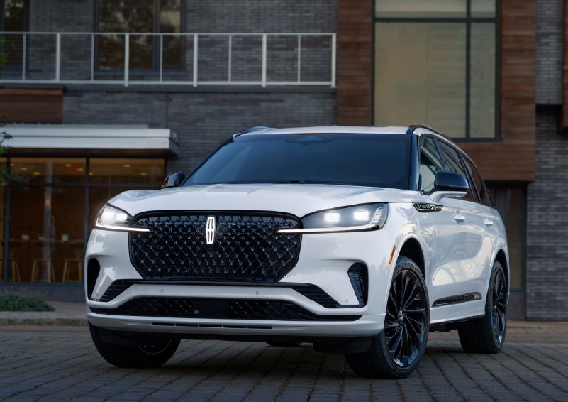 A 2026 Lincoln Aviator® Reserve model is shown with the available Jet Appearance Package parked near a restaurant. | Haldeman Lincoln in Allentown PA