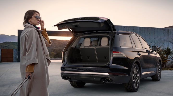 A woman approaches a 2026 Lincoln Aviator® SUV with its rear liftgate open. | Haldeman Lincoln in Allentown PA