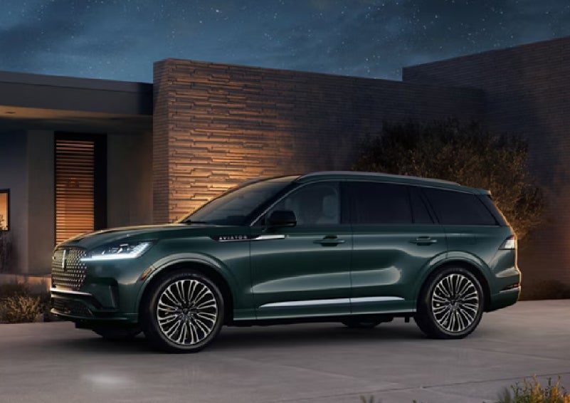A green 2027 Lincoln Aviator® SUV is parked outside a contemporary home. | Haldeman Lincoln in Allentown PA