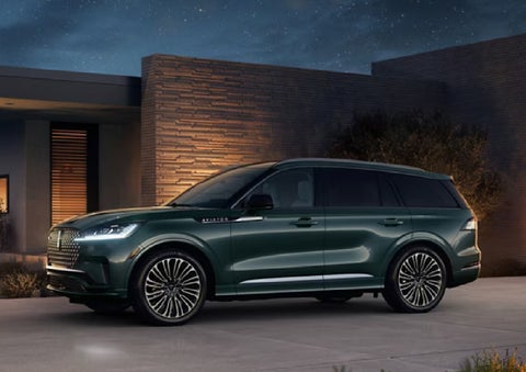 A green 2027 Lincoln Aviator® SUV is parked outside a contemporary home. | Haldeman Lincoln in Allentown PA