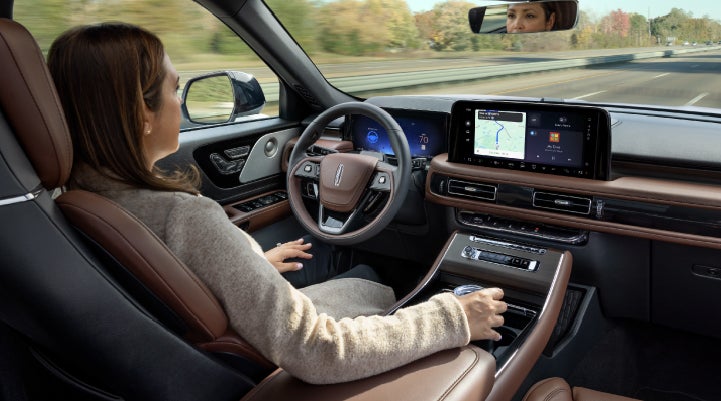 A 2027 Lincoln Aviator® SUV is being driven hands-free on a highway lined with trees. | Haldeman Lincoln in Allentown PA