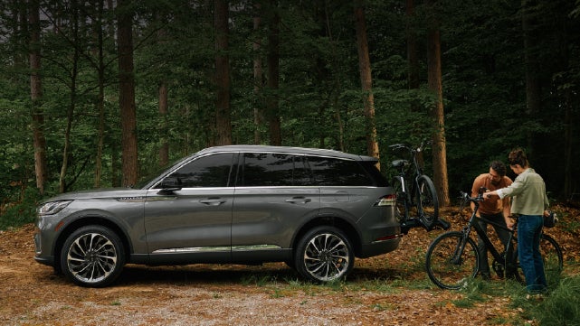 A father and son load e-bikes on a bike rack attached to a 2027 Lincoln Aviator® SUV. | Haldeman Lincoln in Allentown PA