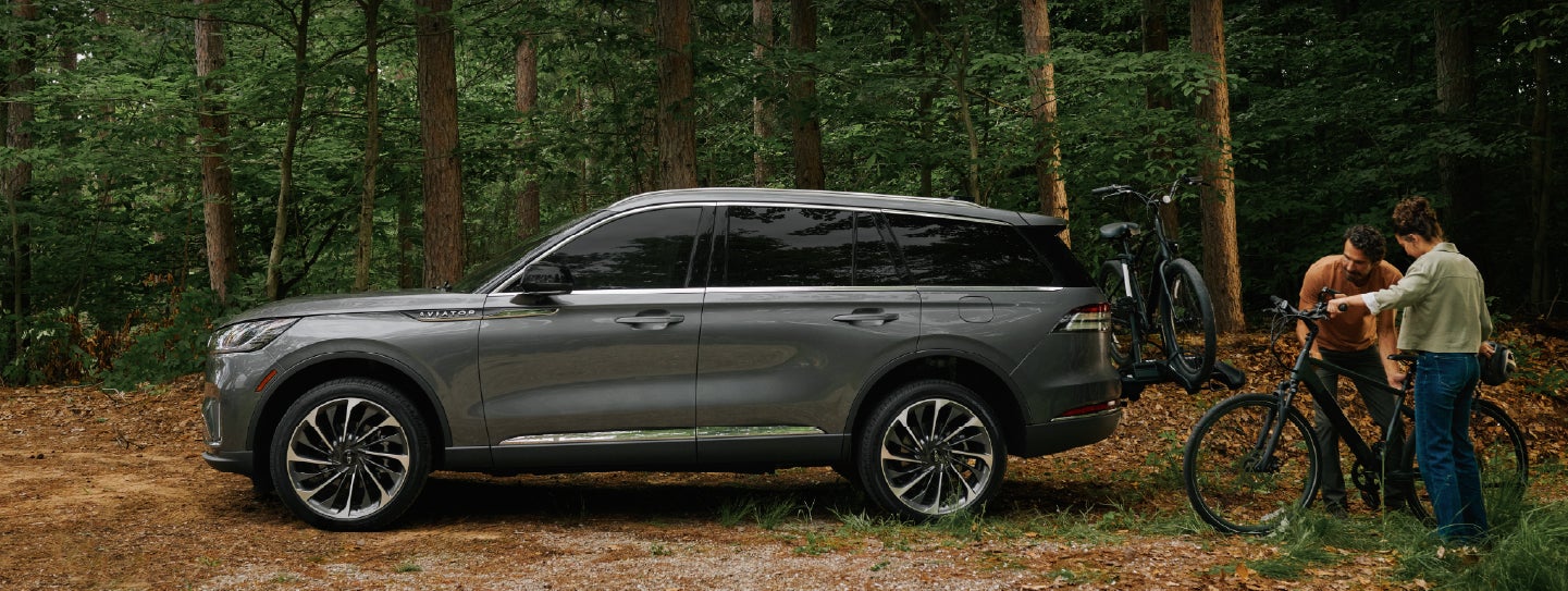 A father and son load e-bikes on a bike rack attached to a 2027 Lincoln Aviator® SUV. | Haldeman Lincoln in Allentown PA