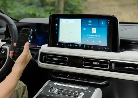 A person pairs thier phone with the center touchscreen of a 2027 Lincoln Aviator® Black Label™ SUV | Haldeman Lincoln in Allentown PA